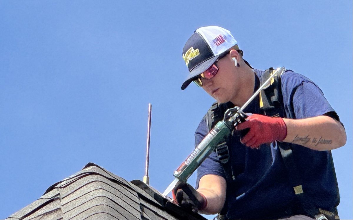 WB Lightning Rods installer fitting a low-profile lightning rod on a roof ridge